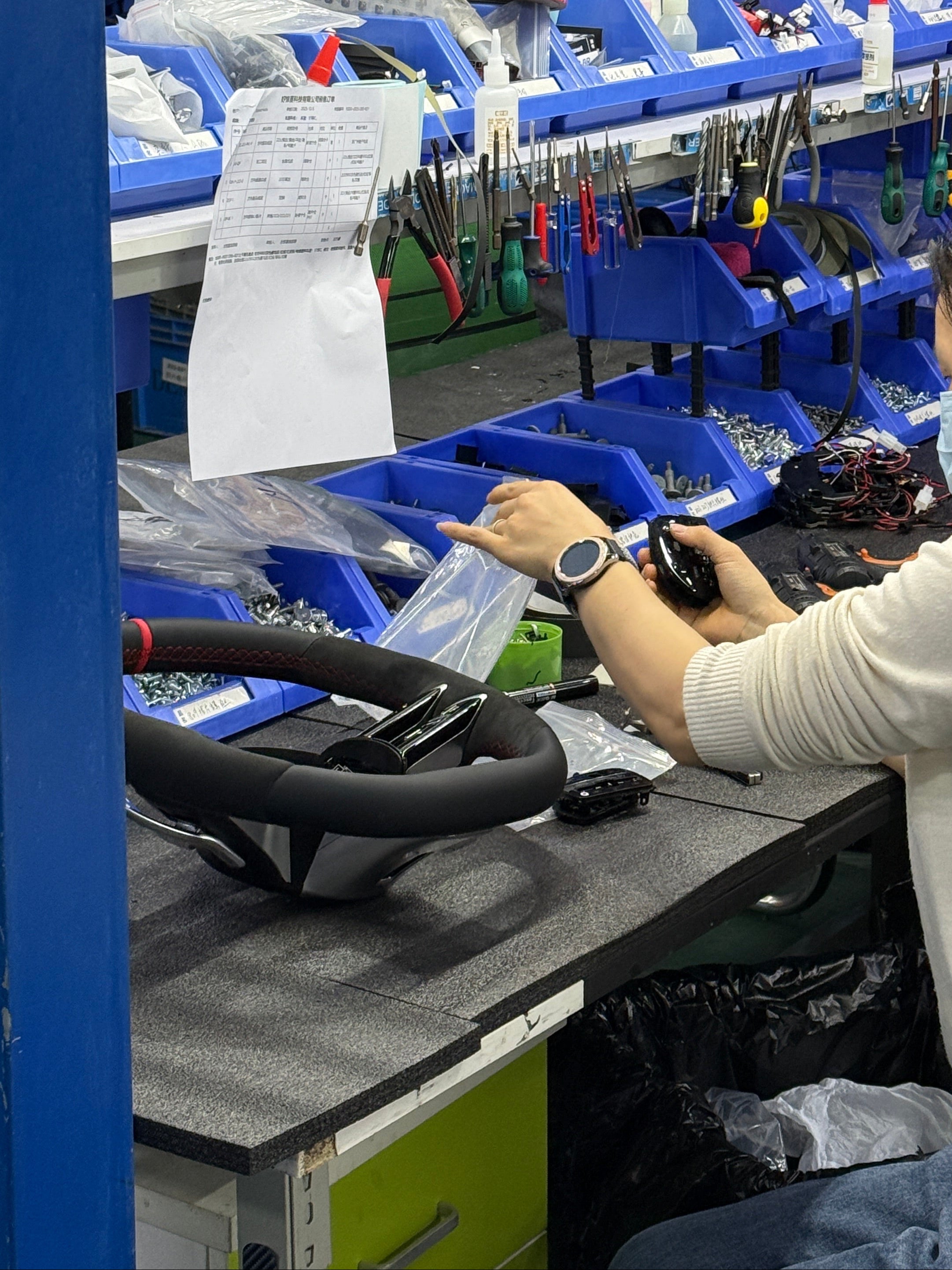 Person working with tools on a shelf in a workshop setting